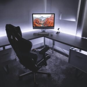 Sleek office desk setup featuring a gaming chair and widescreen monitor, ideal for productivity and gaming.